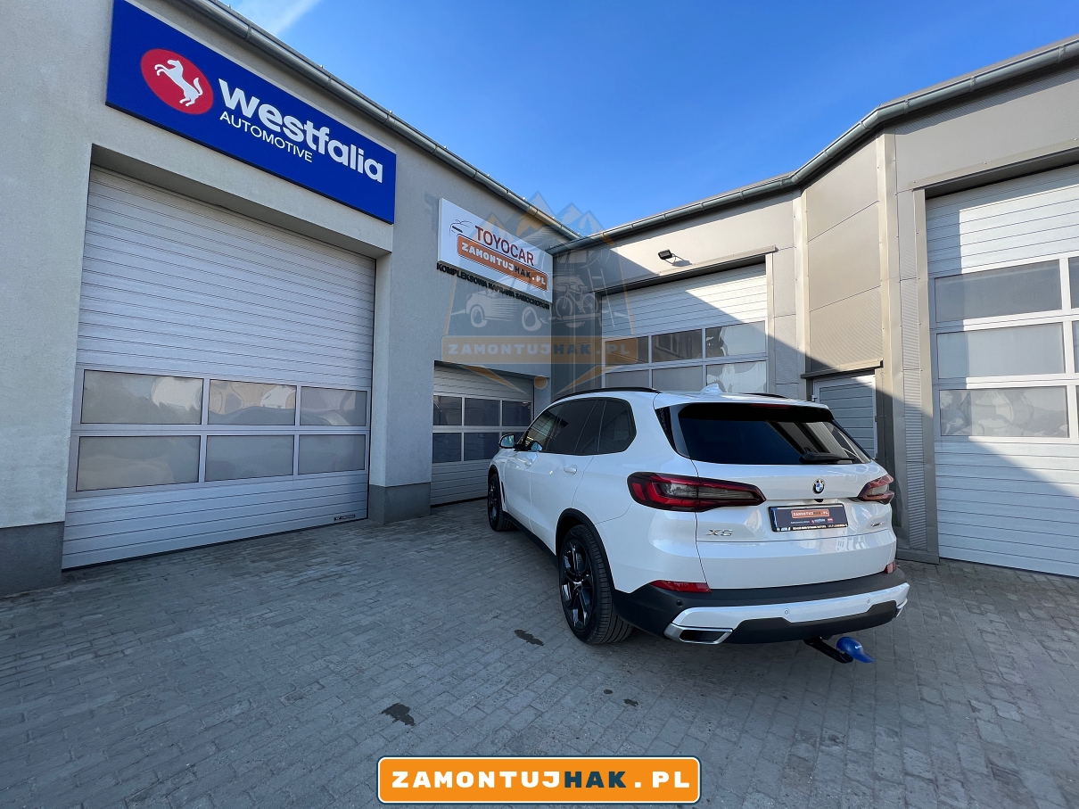 zdjecie samochodu bmw x5 g05 na tle profesjonalnego warsztatu samochodowego w wysogotowie pod poznaniem zajmującego sie profesjonalnym montażem haków holowniczych 